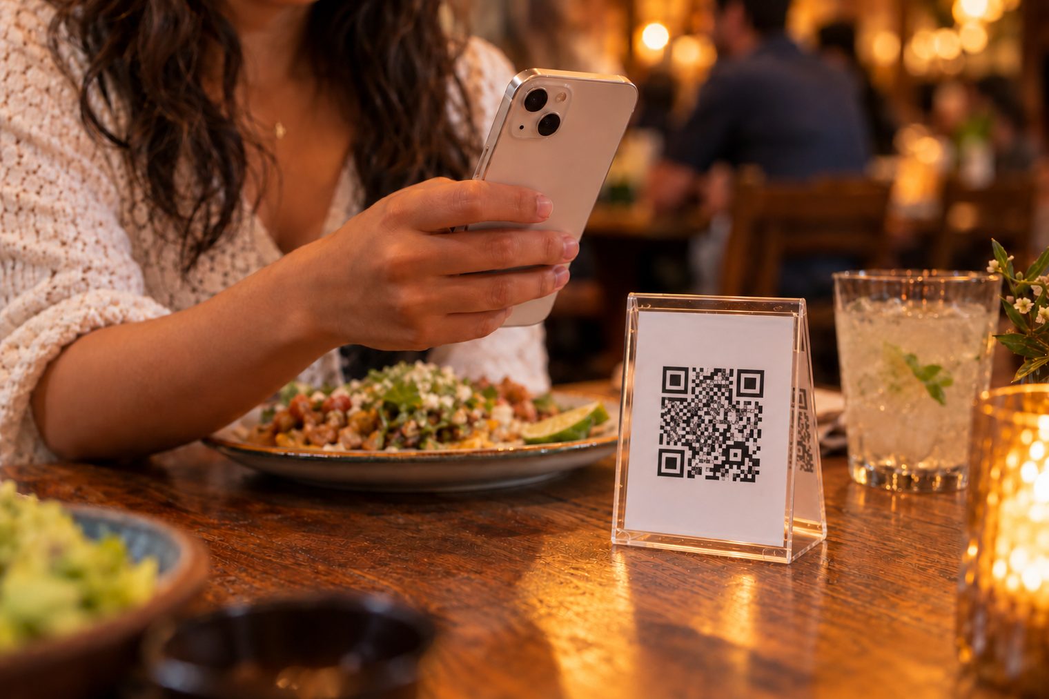 Una clienta escanea con su teléfono el código QR que está sobre la mesa.